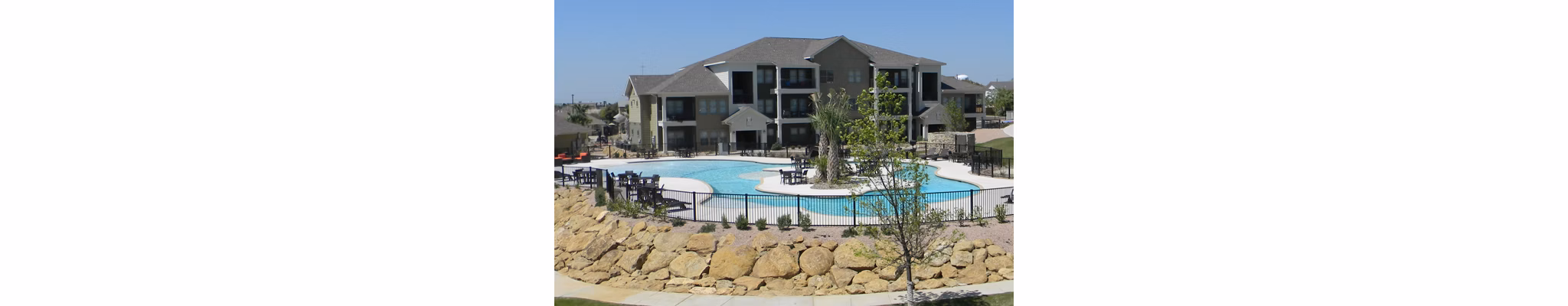 Relaxing poolside oasis at La Contessa Apartments with lush landscaping