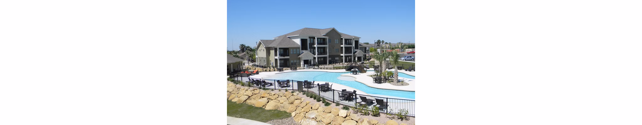 Pool with sun loungers at La Contessa Apartments, offering luxury amenities and leisure spaces for residents