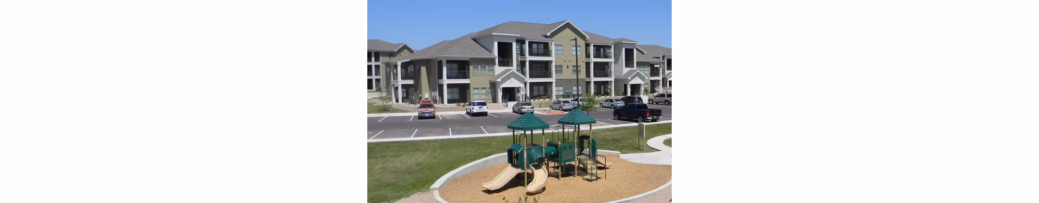La Contessa Apartments: Colorful children's playground with slides and swings in a luxury living community