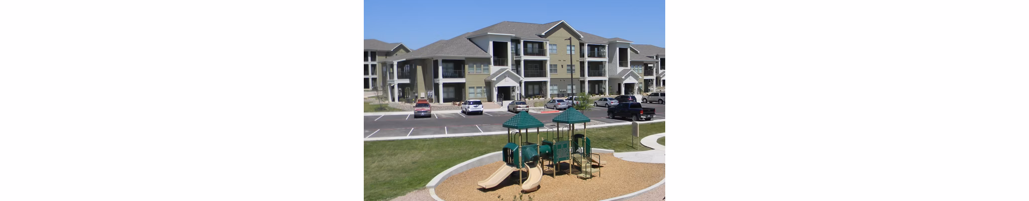 La Contessa Apartments: Colorful children's playground with slides and swings in a luxury living community