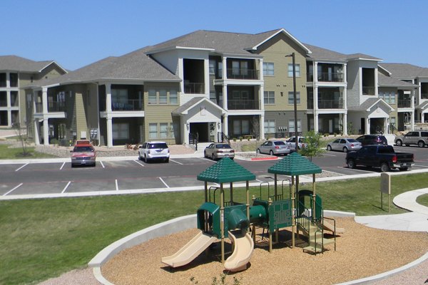 La Contessa Apartments: Colorful children's playground with slides and swings in a luxury living community