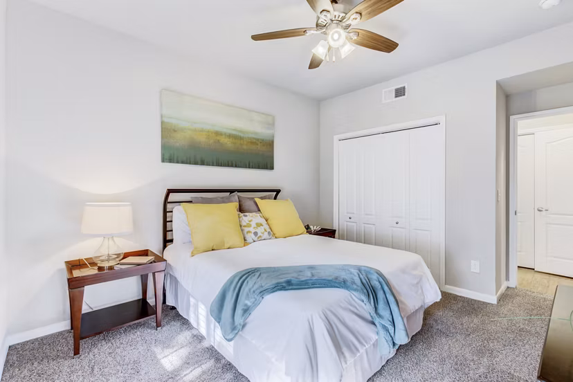 Elegant bedroom with modern furnishings at Riviera at West Village Apartments