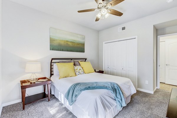 Elegant bedroom with modern furnishings at Riviera at West Village Apartments