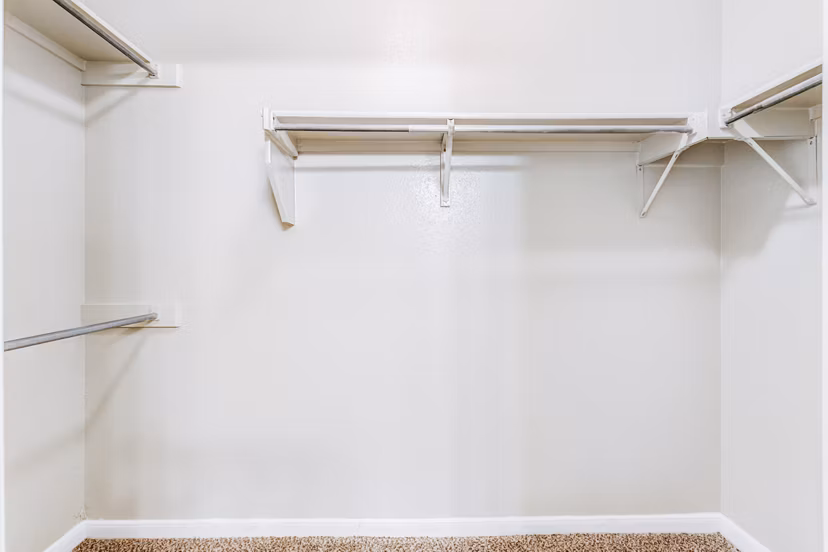 Walk-in closet with ample storage in Riviera at West Village Apartments, luxury living