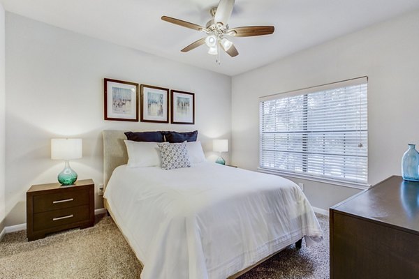Cozy bedroom with modern decor at Riviera at West Village Apartments, featuring comfortable bed and ample natural light