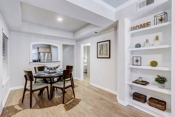 Dining room with modern furniture and elegant lighting at Riviera at West Village Apartments, offering luxury living spaces