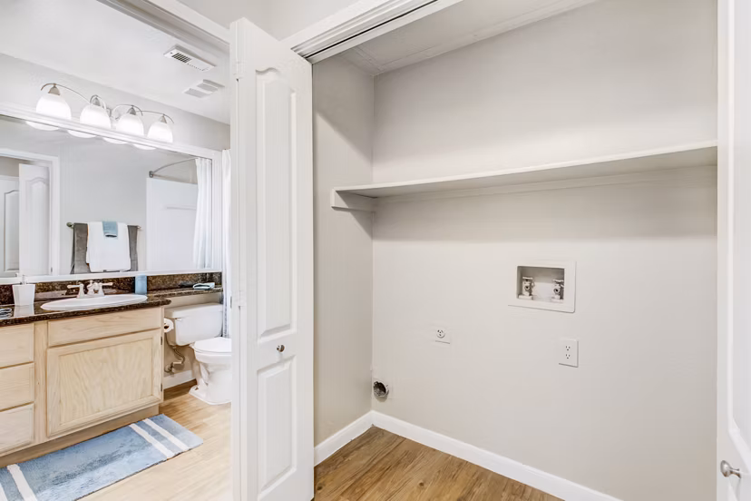 Modern laundry room with high-efficiency washers and dryers at Riviera at West Village Apartments