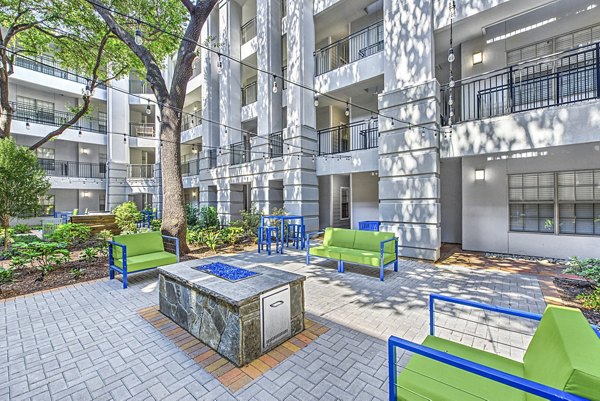 Fire pit lounge area with cozy seating at Riviera at West Village Apartments, offering a luxurious outdoor experience for residents