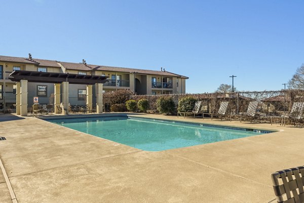 Relaxing poolside area with lounge chairs at The Reserve Apartments