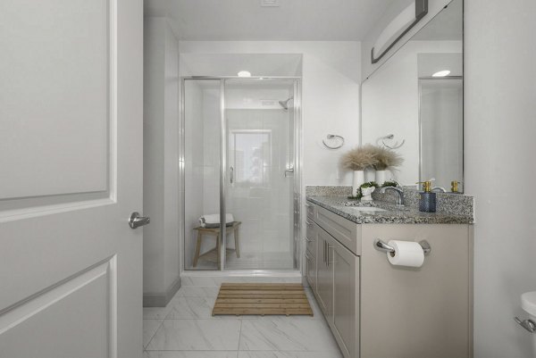 Bathroom featuring sleek fixtures and elegant tile work at Skyhouse Uptown North Apartments