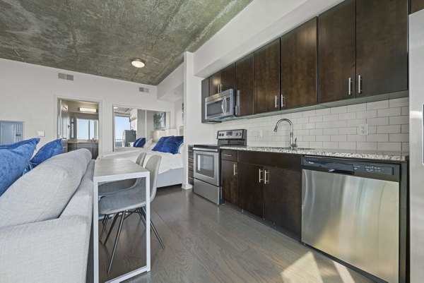 Modern kitchen with granite countertops and stainless steel appliances at Skyhouse Uptown North Apartments