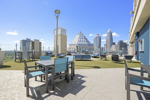 Cozy outdoor patio at Skyhouse Uptown North Apartments featuring modern seating and city views