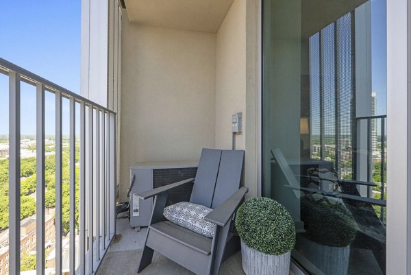 Outdoor patio featuring modern seating and lush greenery at Skyhouse Uptown North Apartments