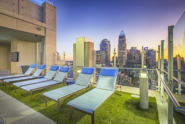 Scenic pool patio with modern lounge seating at Skyhouse Uptown North Apartments, a luxury community managed by Greystar