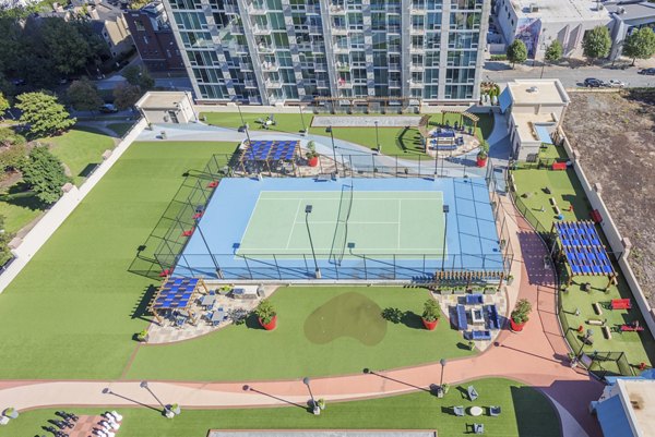 Outdoor sport court adjacent to the patio area at Skyhouse Uptown North Apartments, offering recreational activities for residents