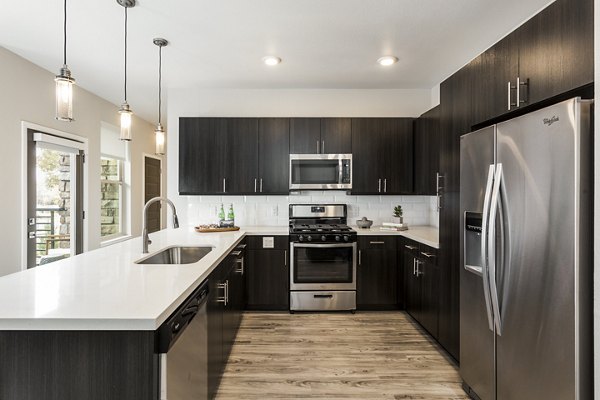 Modern kitchen with stainless steel appliances at Solana Olde Town Station Apartments