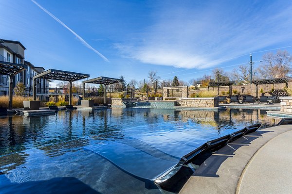 Resort-style swimming pool with lounge chairs at Solana Olde Town Station Apartments, ideal for relaxation and social gatherings