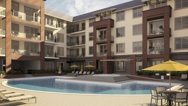 Luxury apartment complex with a swimming pool, lounge chairs, and umbrellas in a beautiful outdoor setting