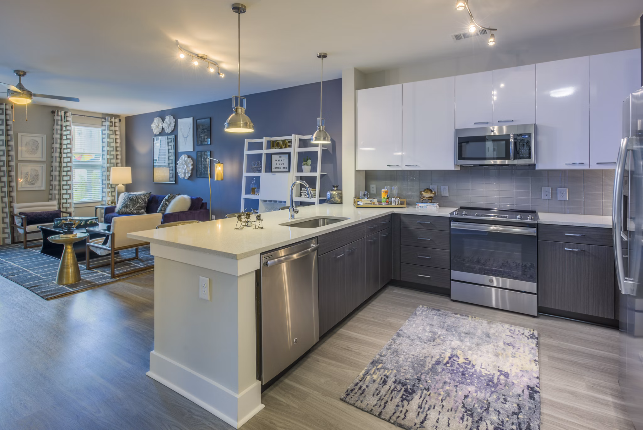 Warm, open-concept kitchen with stainless steel appliances at Cadence Music Factory Apartments