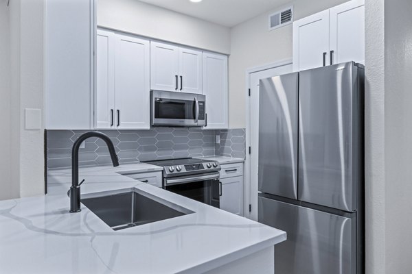 Modern kitchen with stainless steel appliances and granite countertops at Haven at Midtown Apartments