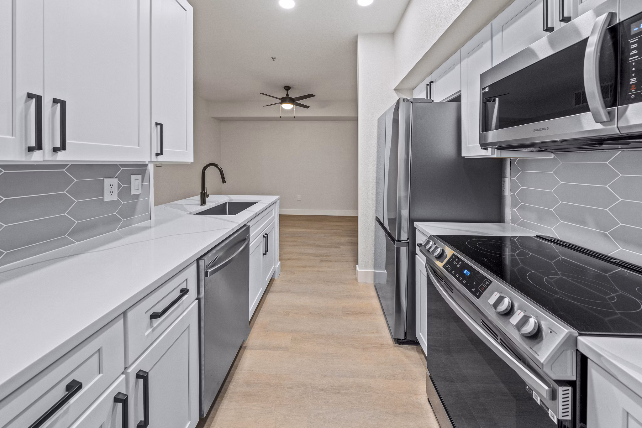 Modern kitchen with stainless steel appliances and quartz countertops at Haven at Midtown Apartments