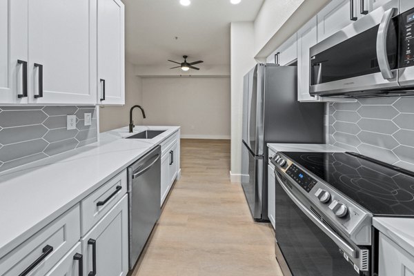 Modern kitchen with stainless steel appliances and quartz countertops at Haven at Midtown Apartments