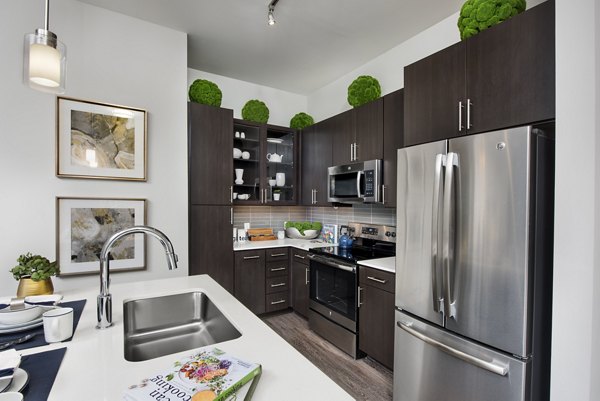 Modern kitchen with granite countertops and stainless steel appliances at Overture Barrett Apartments