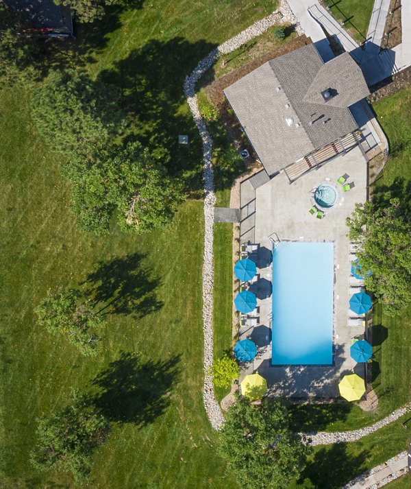 Modern pool area with lounge chairs and umbrellas at Vista at Trappers Glen Apartments