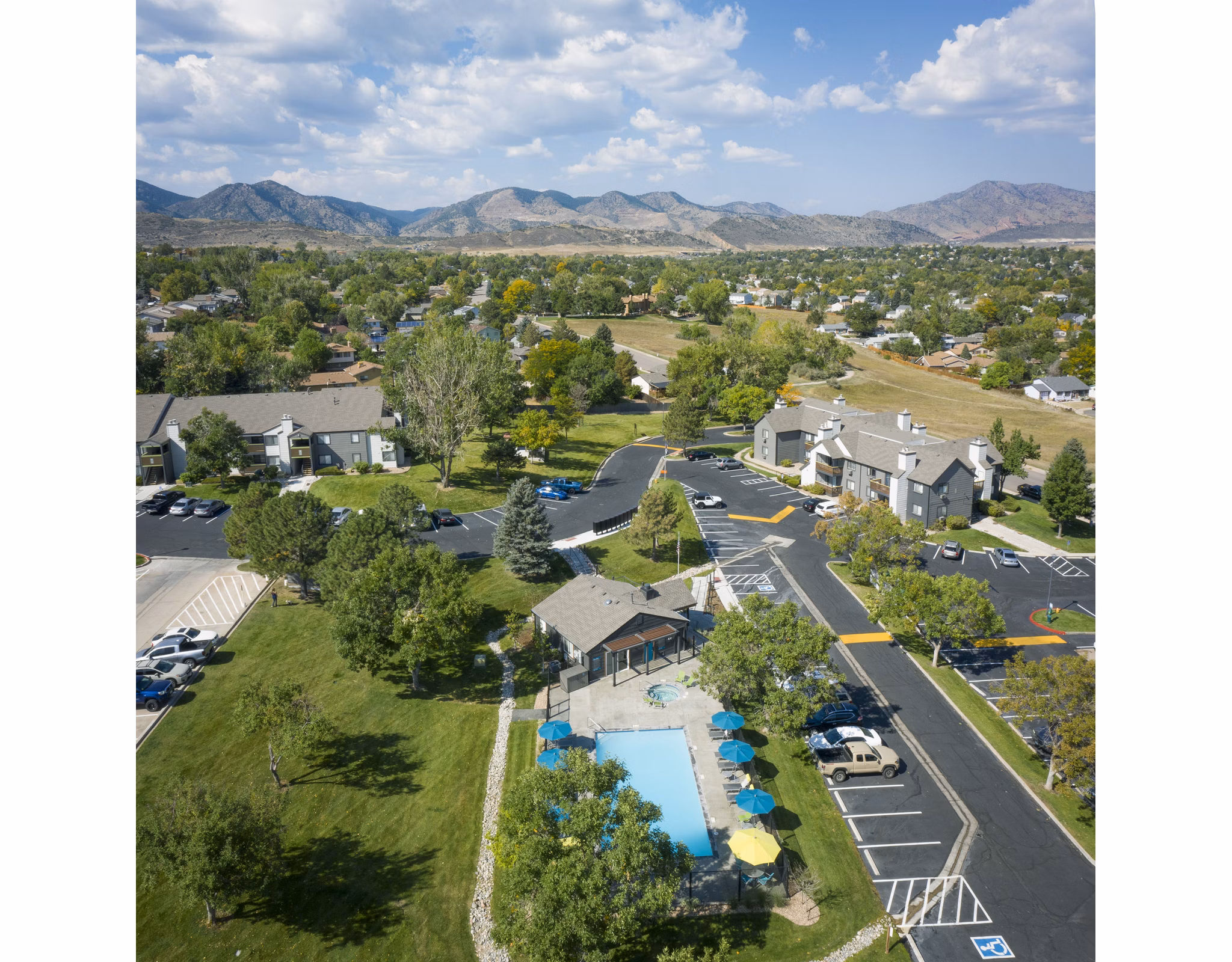 Pool area with sun loungers and lush landscaping at Vista at Trappers Glen Apartments