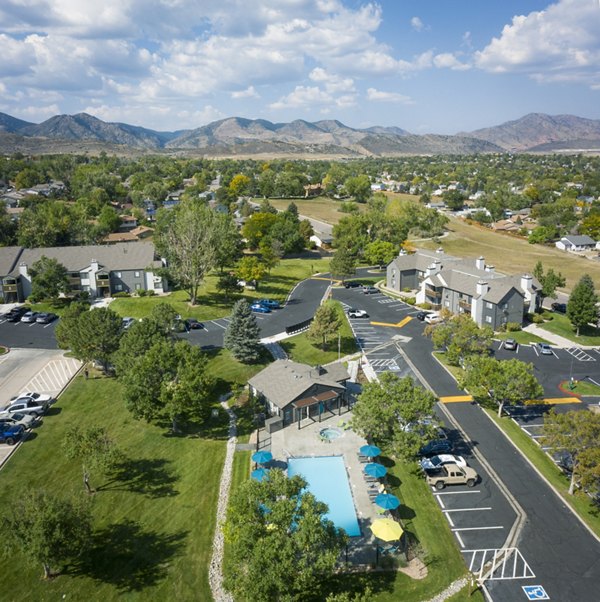 Pool area with sun loungers and lush landscaping at Vista at Trappers Glen Apartments
