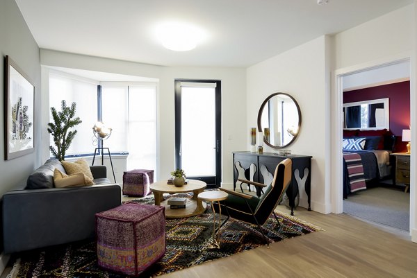 Spacious living room with modern decor in The Martin Apartments featuring floor-to-ceiling windows