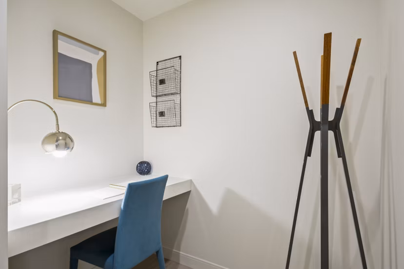 Home office with modern desk and shelving in James and Harrison Court Apartments Ideal workspace with natural lighting and stylish decor