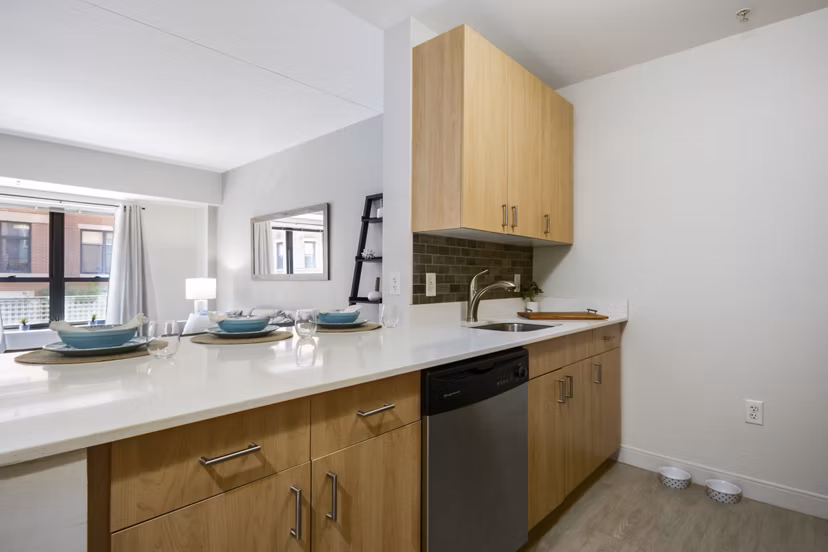 Modern kitchen with stainless steel appliances at James and Harrison Court Apartments