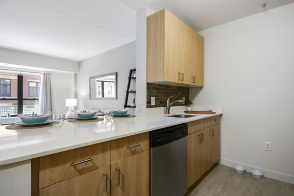 Modern kitchen with stainless steel appliances at James and Harrison Court Apartments