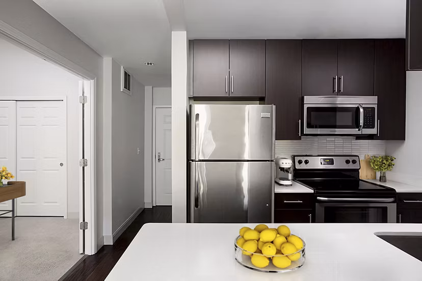 Modern kitchen with sleek cabinetry and granite countertops in James and Harrison Court Apartments