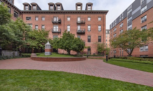 Courtyard with lush greenery and seating at James and Harrison Court Apartments, offering a tranquil outdoor space for residents to relax and unwind