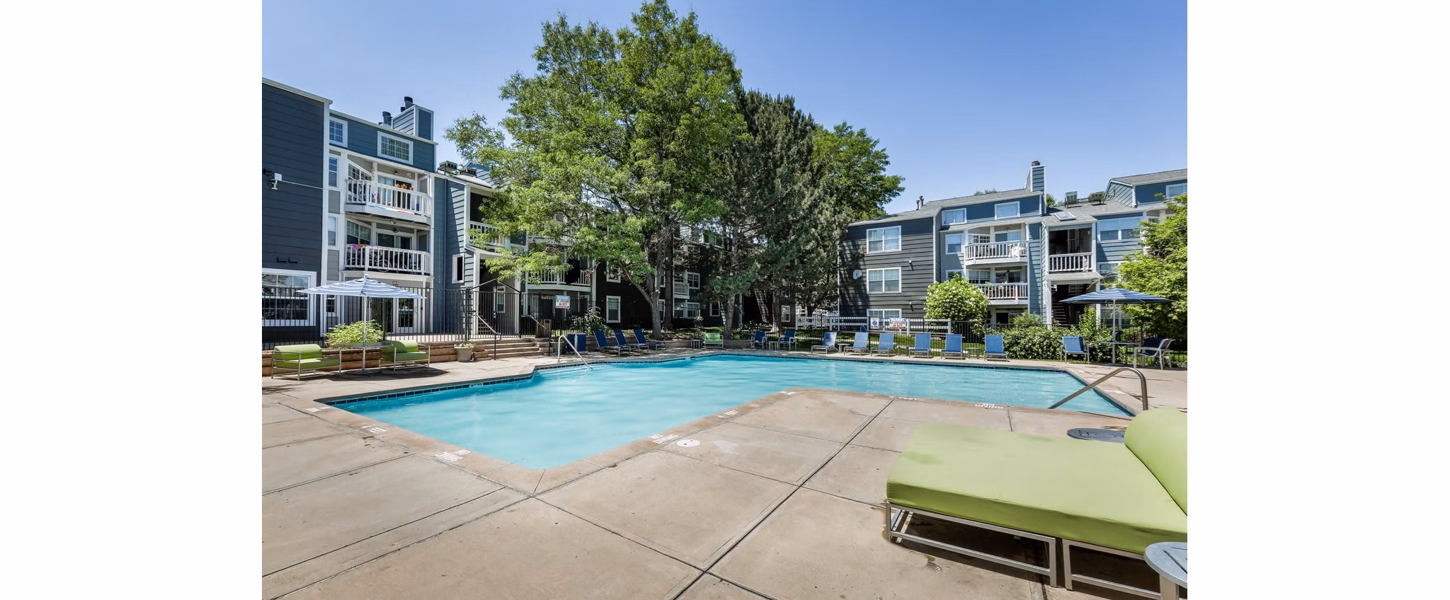 Luxurious outdoor pool area surrounded by lush greenery at Magnolia Ridge Apartments