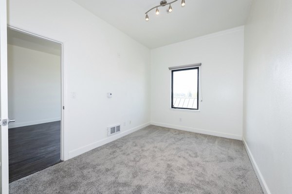 Bedroom featuring modern decor and large windows at 1122 U Apartments, a luxury living space ideal for comfort and style