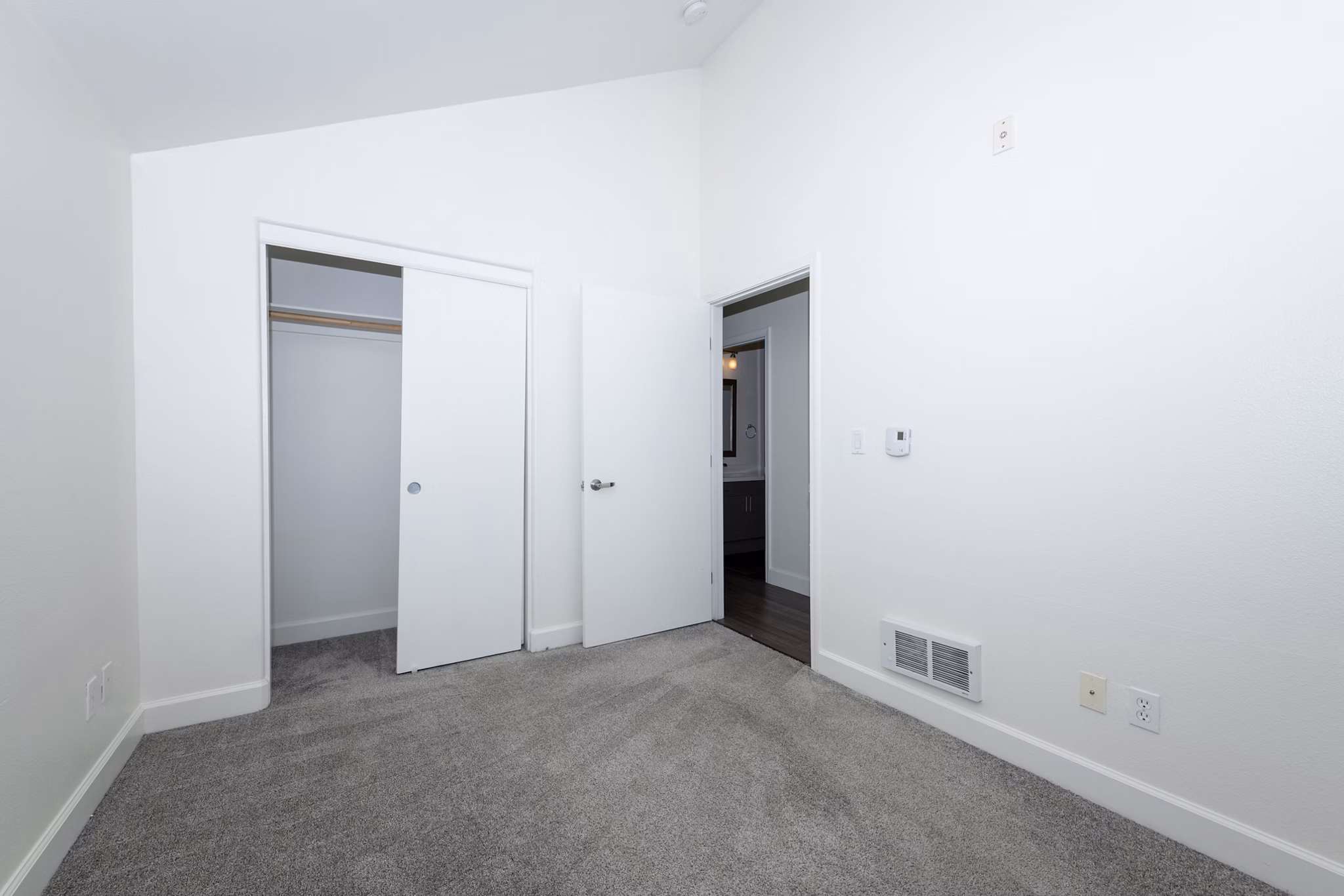 Cozy bedroom with plush bedding at 1122 U Apartments, showcasing luxury living in modern high-rise community