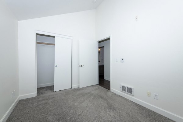 Cozy bedroom with plush bedding at 1122 U Apartments, showcasing luxury living in modern high-rise community