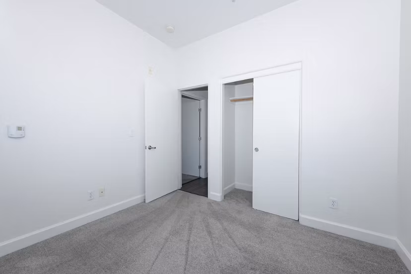 Cozy bedroom with plush bedding at 1122 U Apartments, a luxury Greystar community