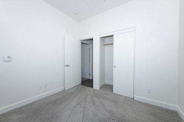 Cozy bedroom with plush bedding at 1122 U Apartments, a luxury Greystar community