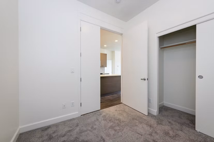 Modern bedroom with large windows and minimalist decor at 1122 U Apartments