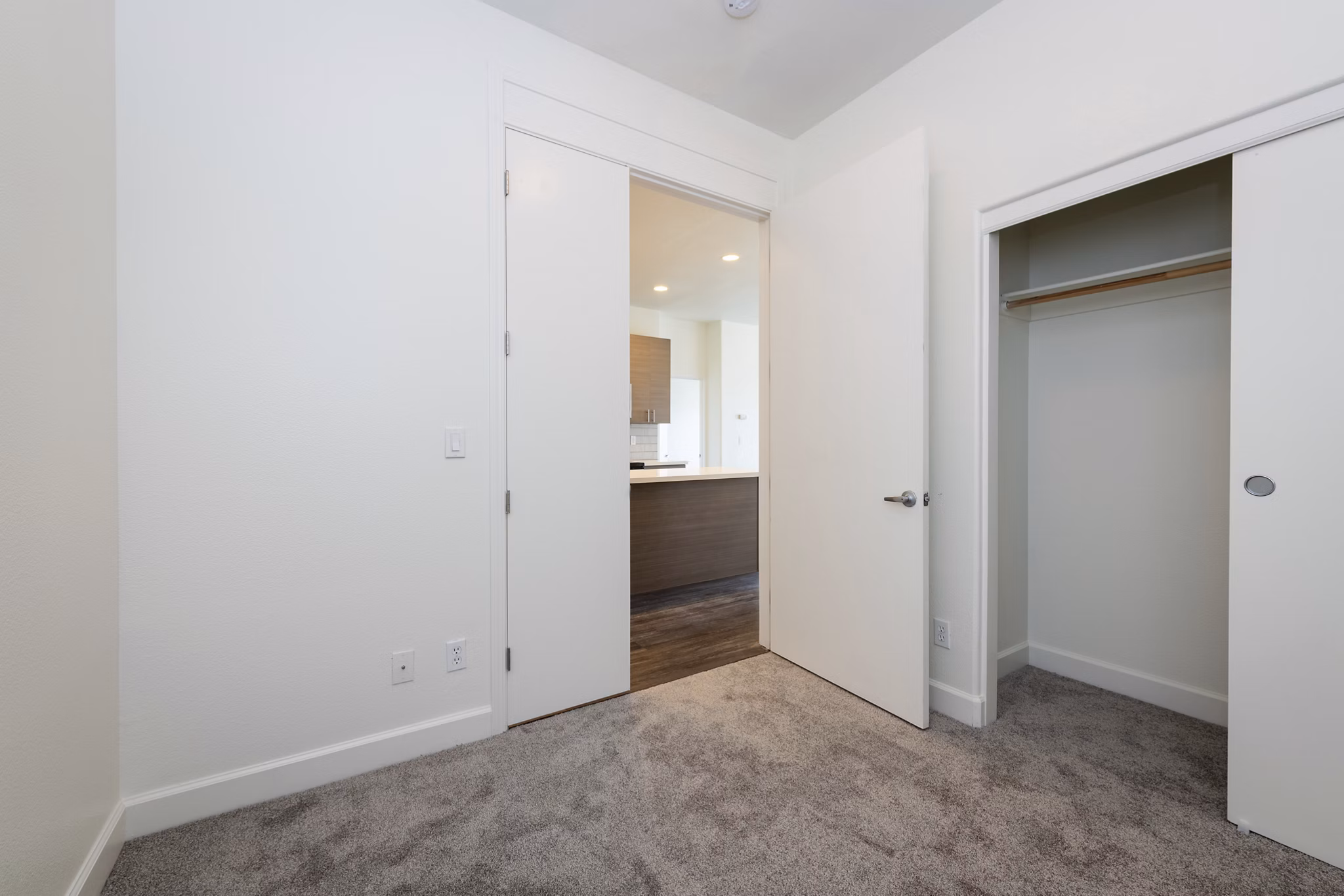 Modern bedroom with large windows and minimalist decor at 1122 U Apartments