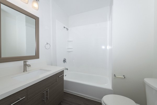 Bathroom featuring sleek fixtures and marble countertops in 1122 U Apartments