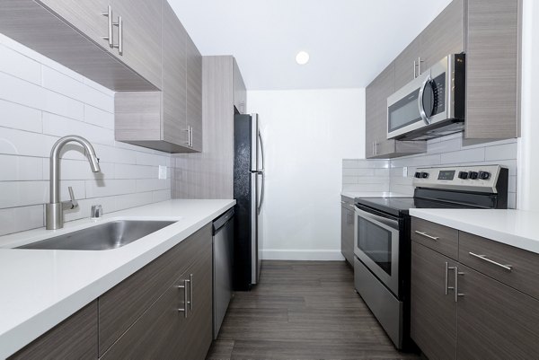 Modern kitchen with stainless steel appliances at 1122 U Apartments, showcasing sleek design and functionality