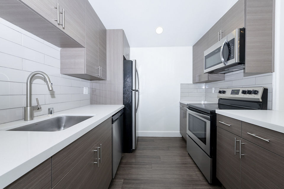 Modern kitchen with stainless steel appliances at 1122 U Apartments, showcasing sleek design and functionality