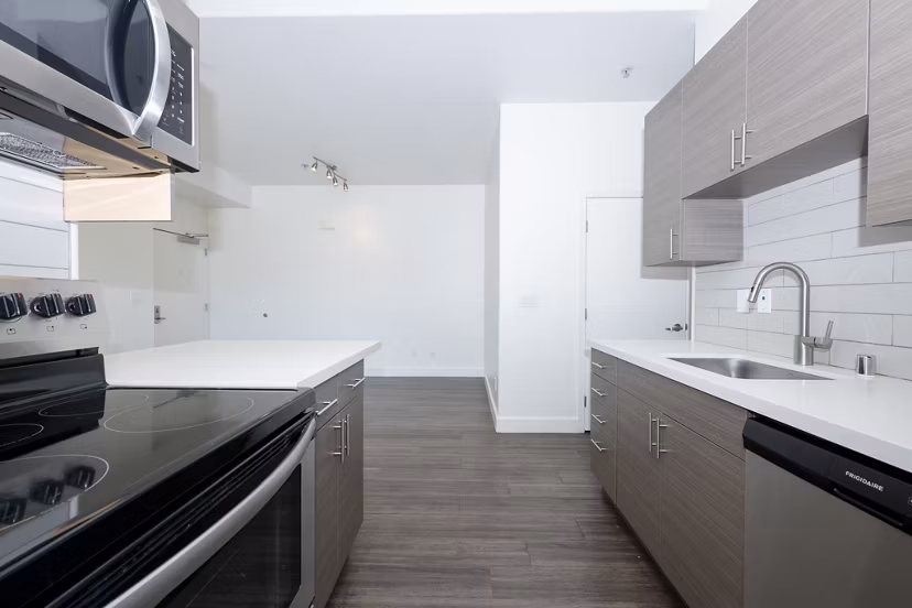 Modern kitchen with stainless steel appliances in 1122 U Apartments