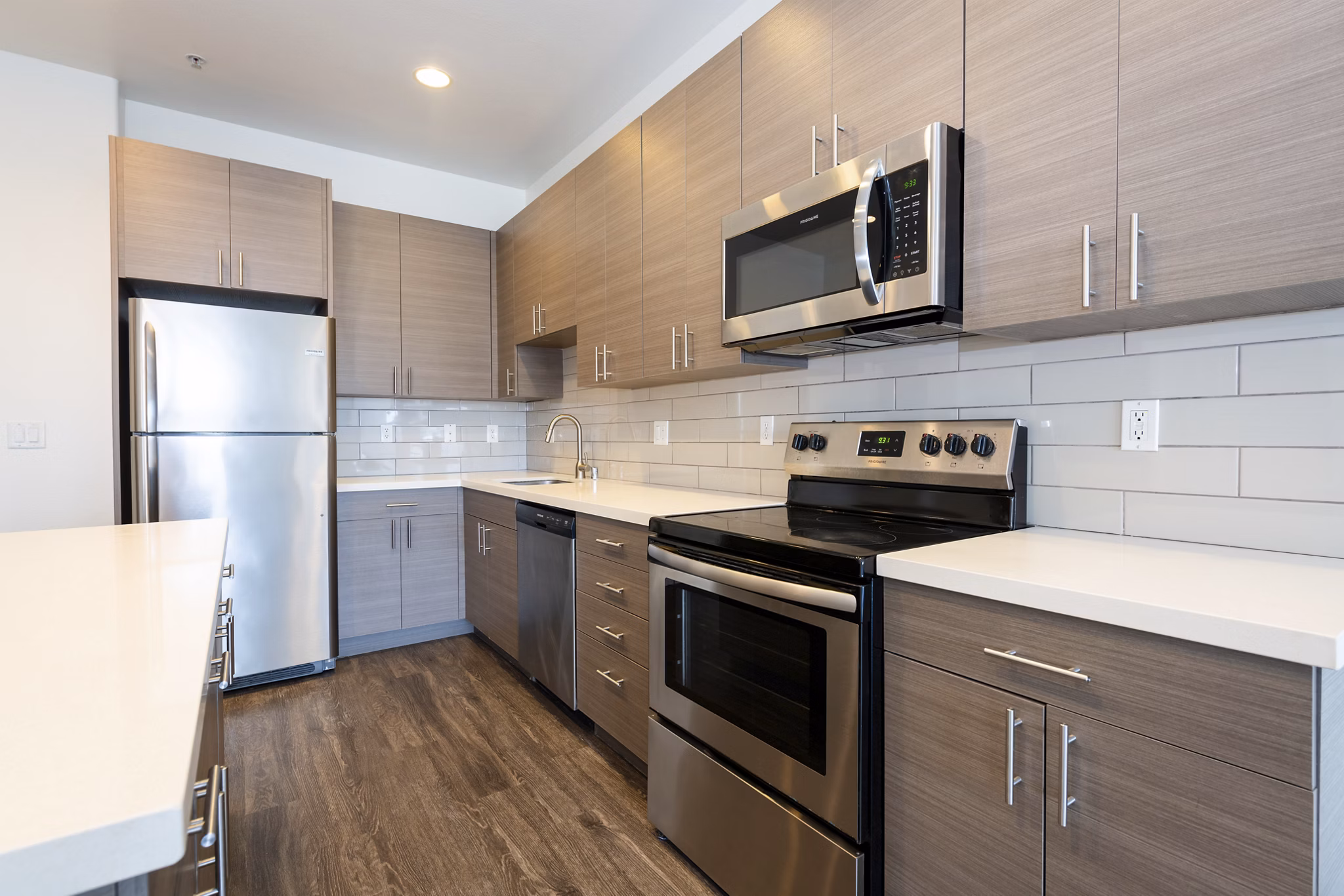 Modern kitchen with stainless steel appliances and sleek countertops at 1122 U Apartments
