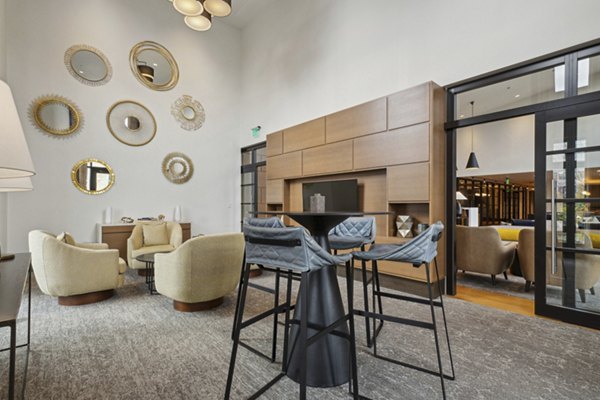 Lounge area with a pool table, comfortable seating, and large TV in luxury apartments